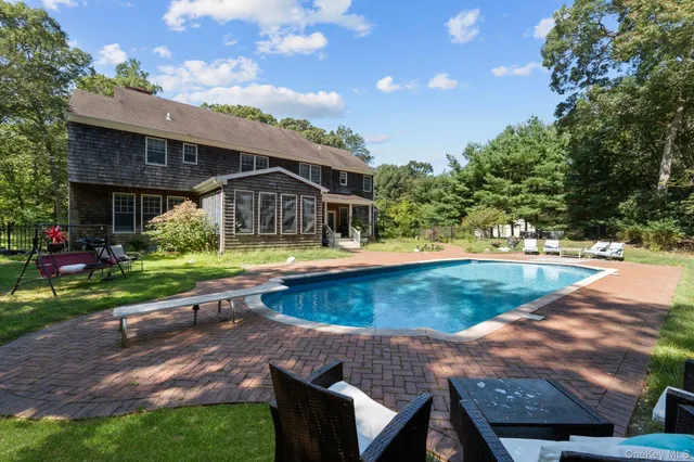 a view of a house with pool and chairs