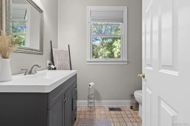 a bathroom with a sink toilet and a mirror