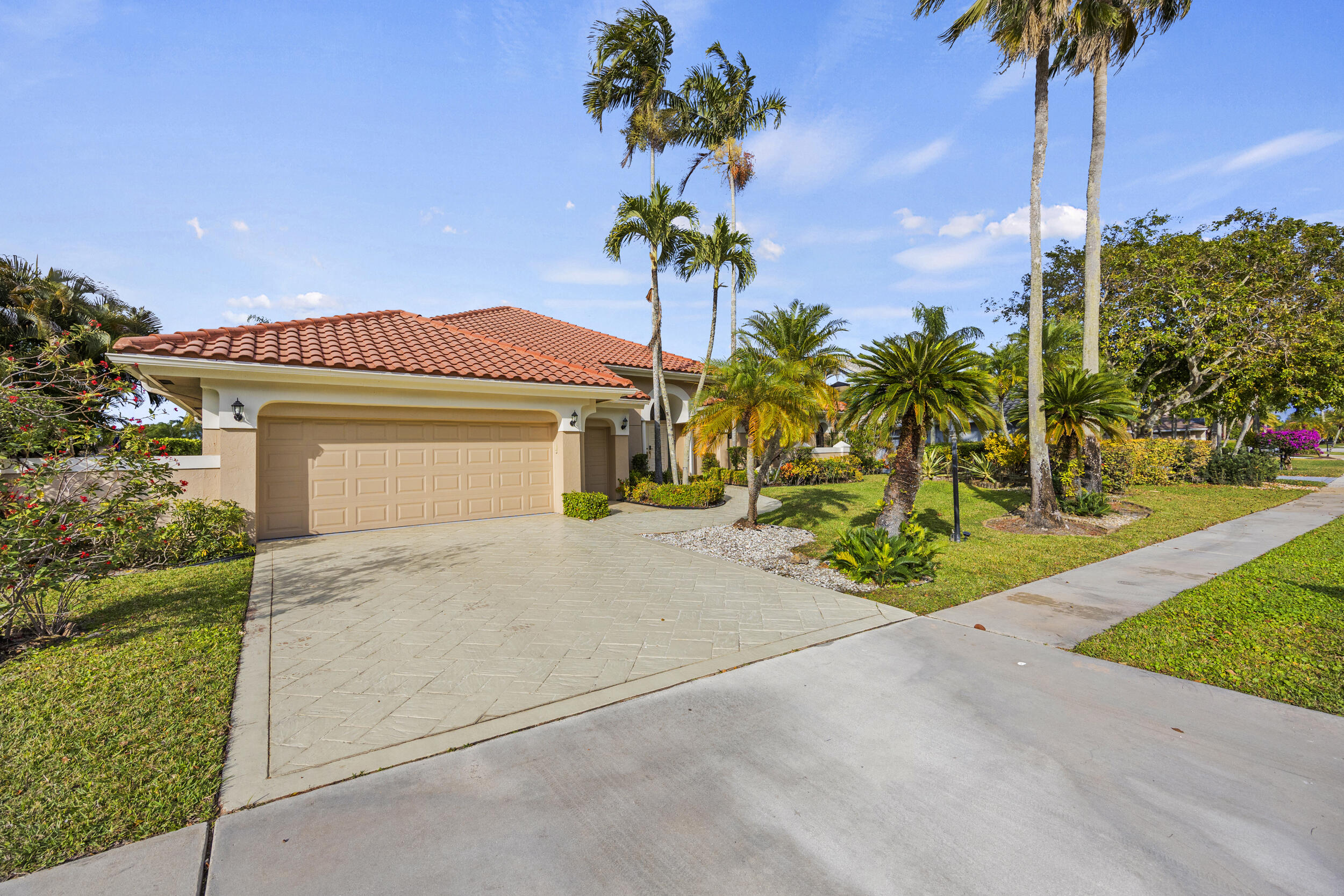 10747 Stonebridge Boulevard Boca Raton, FL 33498 - Photo 65 of 75 a front view of a house with a garden and trees