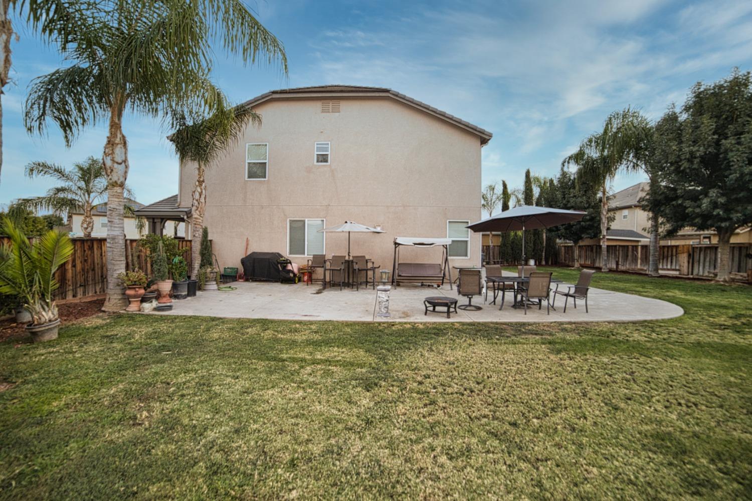 804 Pear Street Madera, CA 93638 - Photo 11 of 27 a view of a swimming pool with a table and chairs under an umbrella