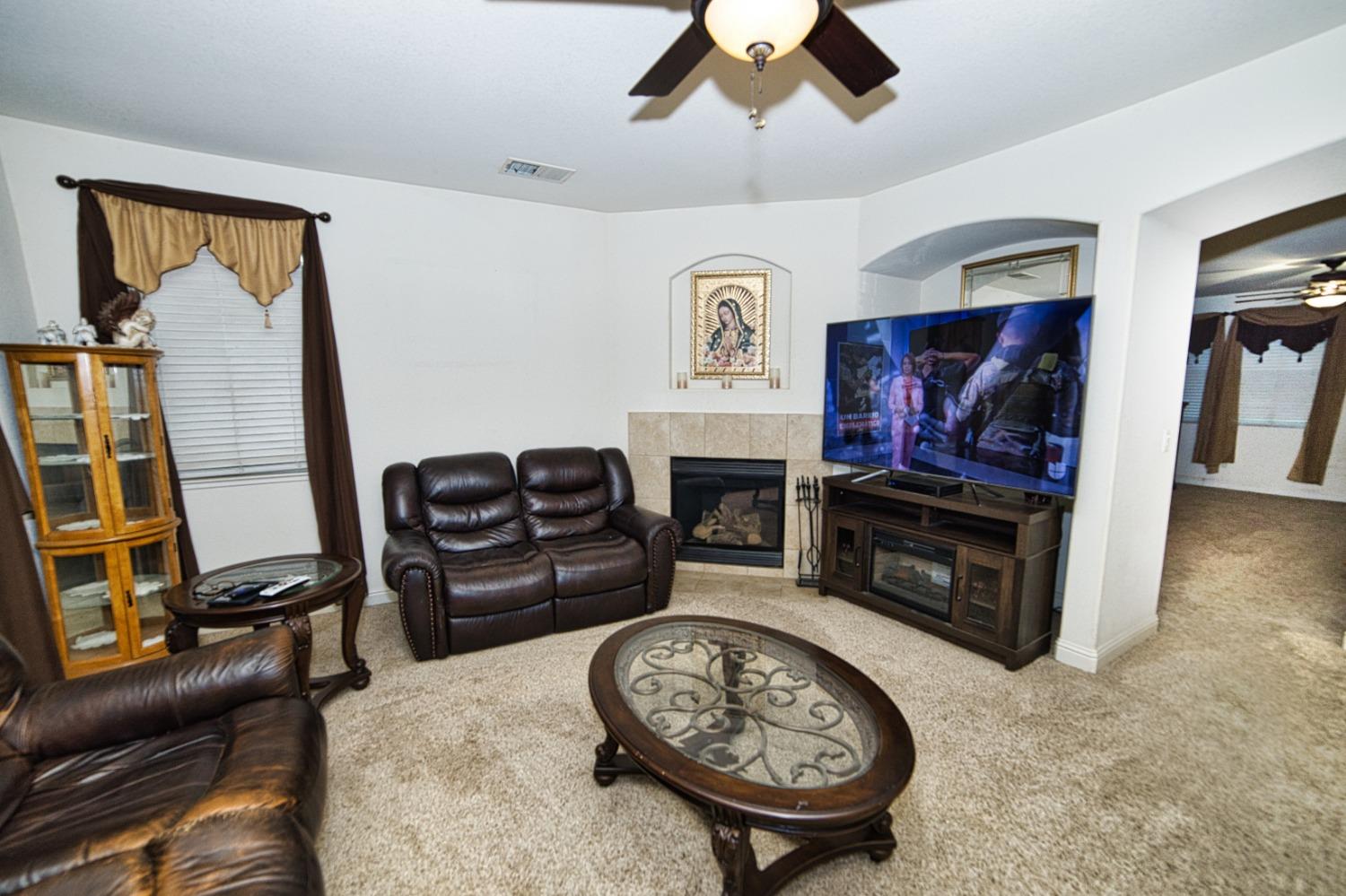 804 Pear Street Madera, CA 93638 - Photo 14 of 27 a living room with furniture a flat screen tv and a fireplace