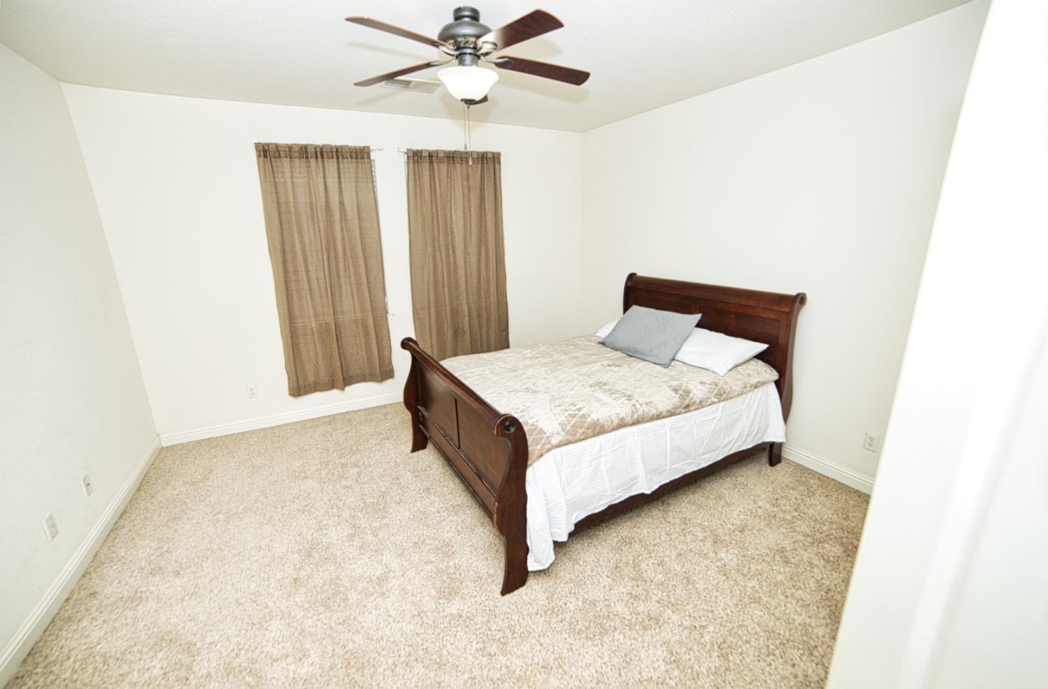 804 Pear Street Madera, CA 93638 - Photo 19 of 27 a bed sitting in a spacious bedroom next to a window