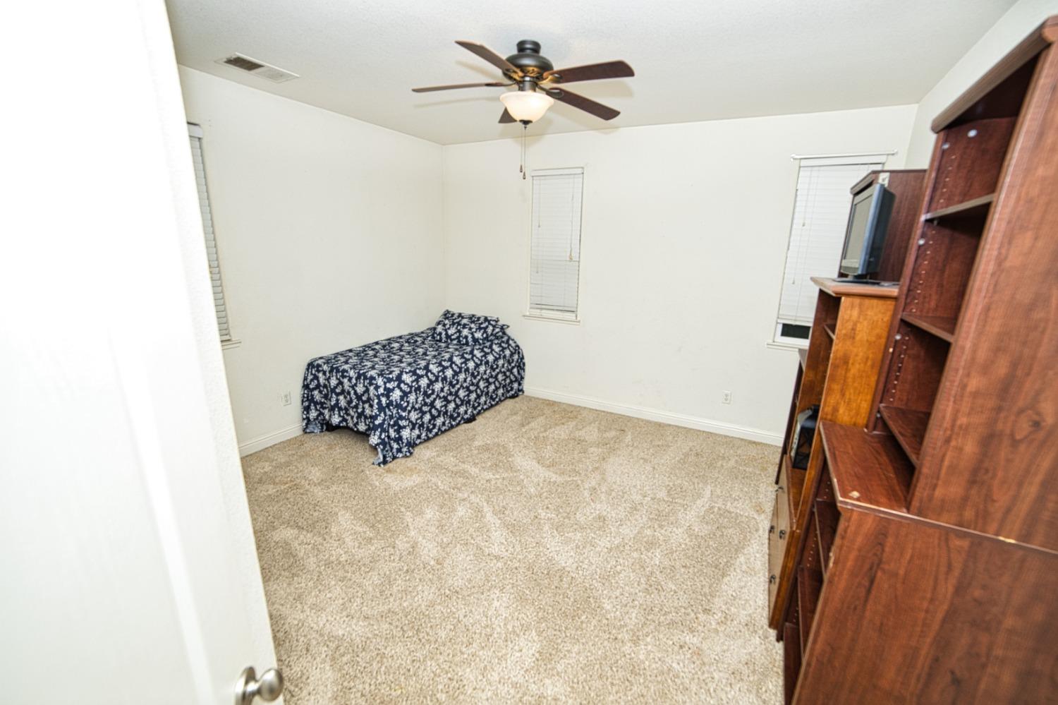 804 Pear Street Madera, CA 93638 - Photo 21 of 27 a bedroom with a bed and a chandelier