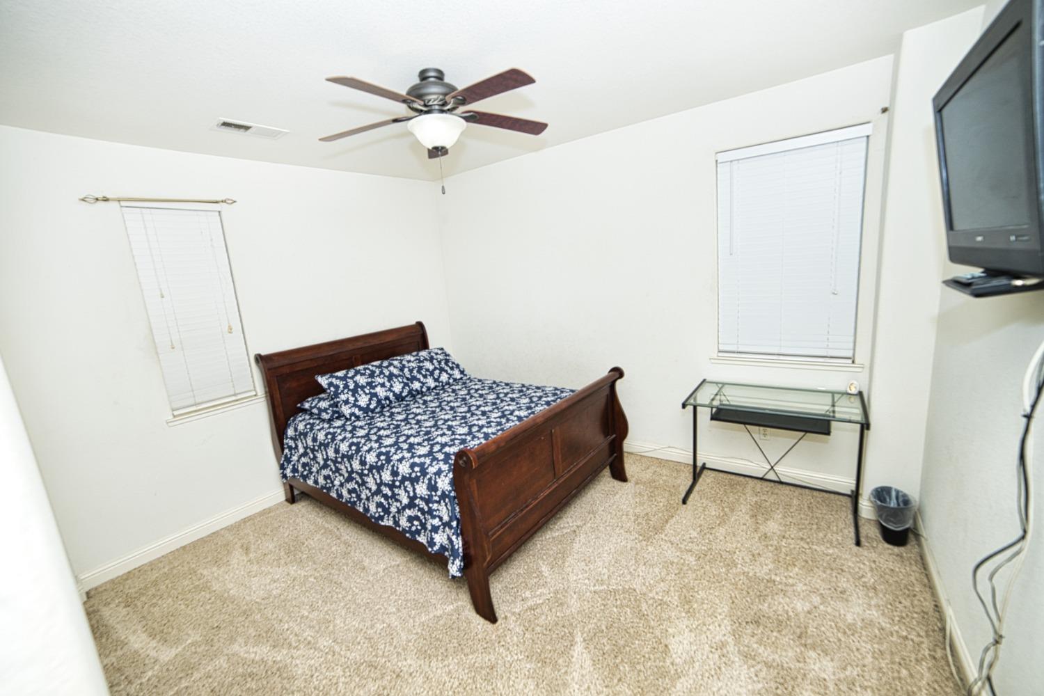 804 Pear Street Madera, CA 93638 - Photo 23 of 27 a bedroom with a bed and a chandelier