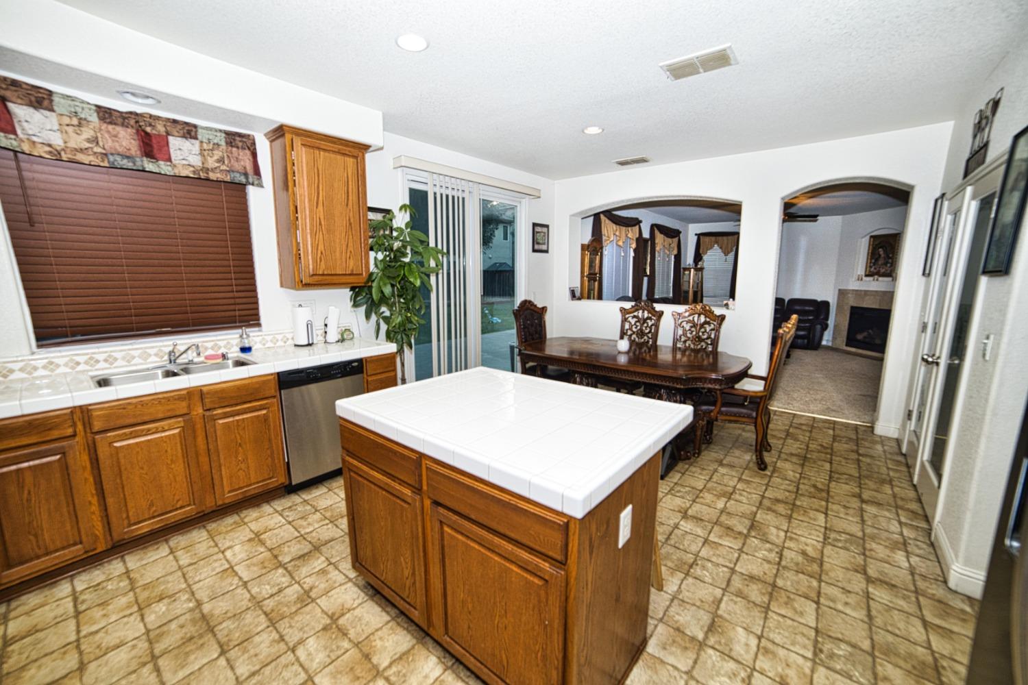 804 Pear Street Madera, CA 93638 - Photo 8 of 27 a living room with stainless steel appliances furniture a rug and a kitchen view