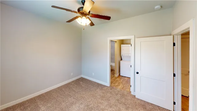 an empty room with a ceiling fan and a window