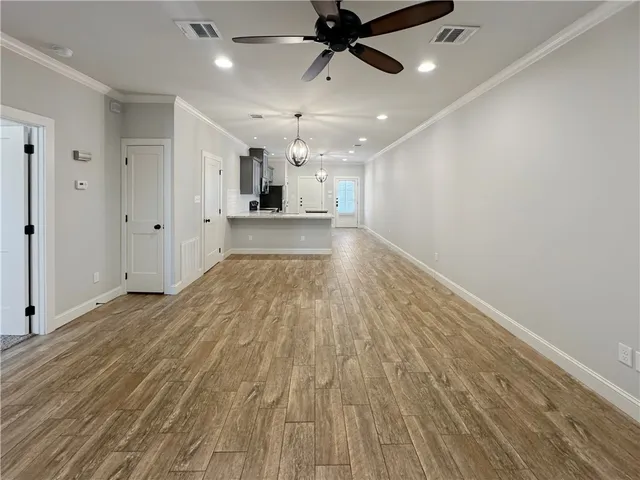 a view of empty room with wooden floor