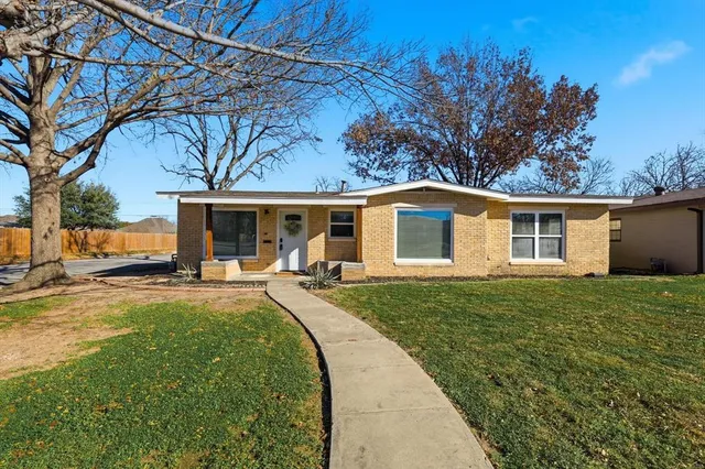 a view of a house with backyard and sitting area