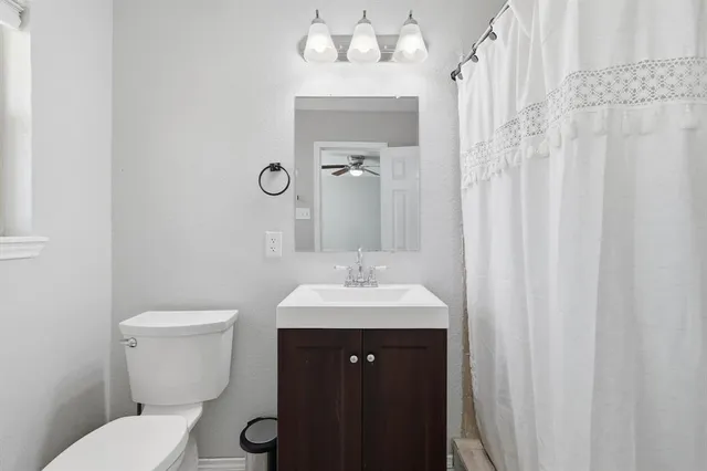 a bathroom with a toilet a sink and a mirror