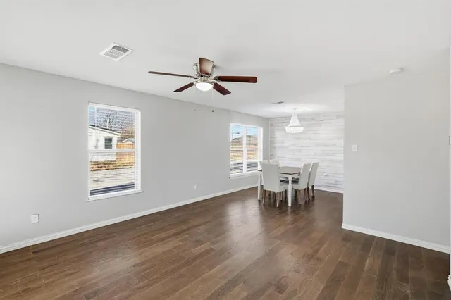 a view of a livingroom with furniture a ceiling fan and wooden floor