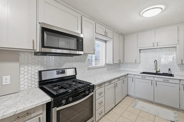 a kitchen with cabinets stainless steel appliances and a sink