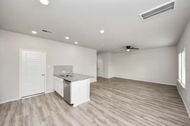 a kitchen with granite countertop a sink and a stove top oven