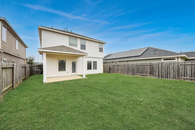 a view of a yard in front of a house with large trees