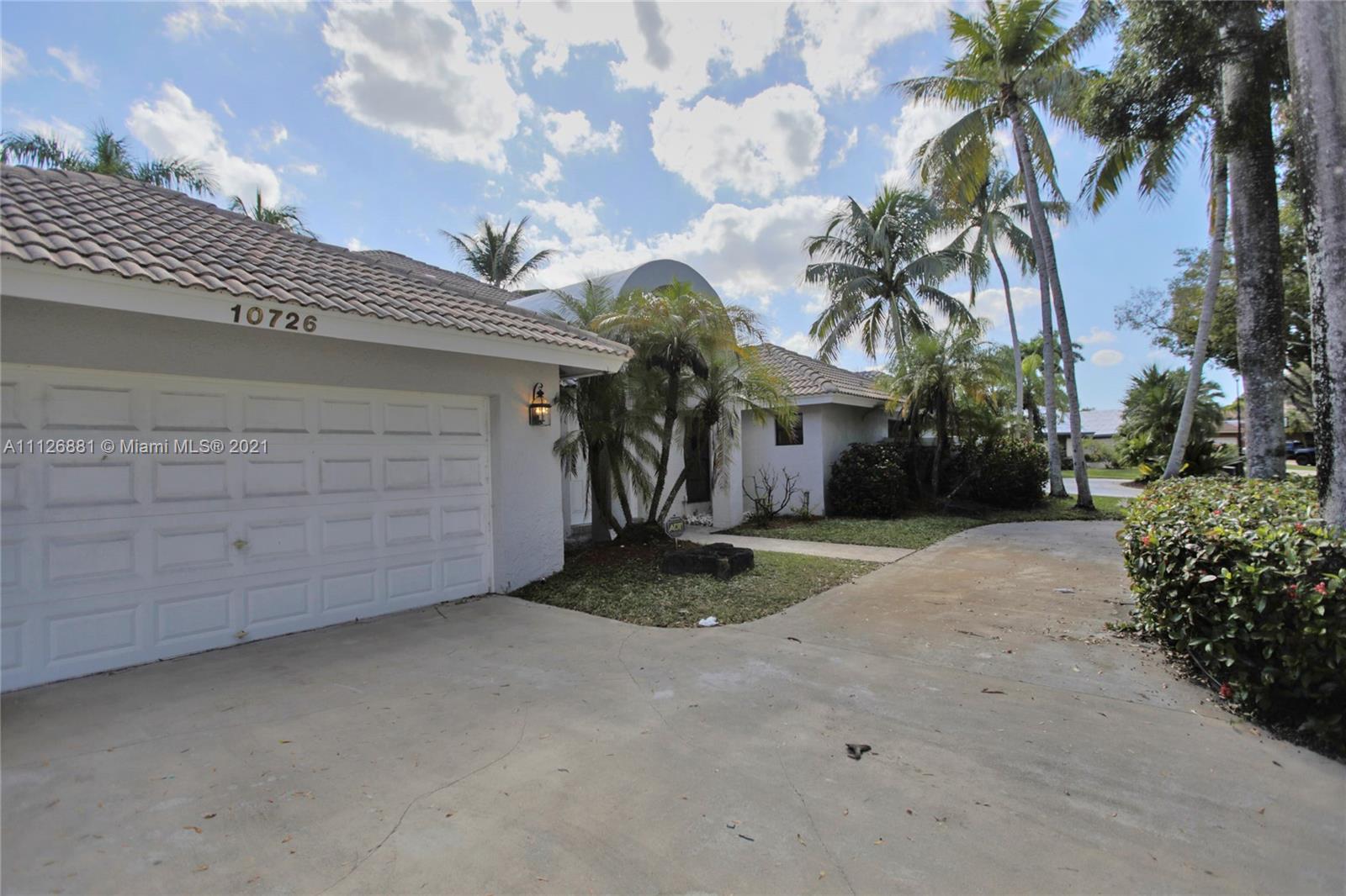 10726 Santa Rosa Drive Boca Raton, FL 33498 - Photo 2 of 26 a view of a house with a yard and garage