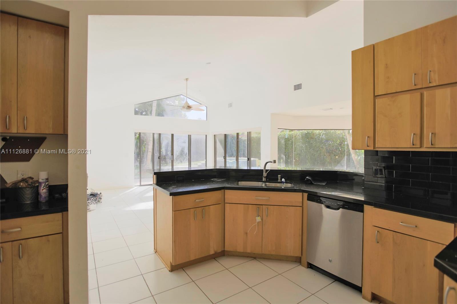 10726 Santa Rosa Drive Boca Raton, FL 33498 - Photo 14 of 26 a kitchen with granite countertop a sink and white cabinets