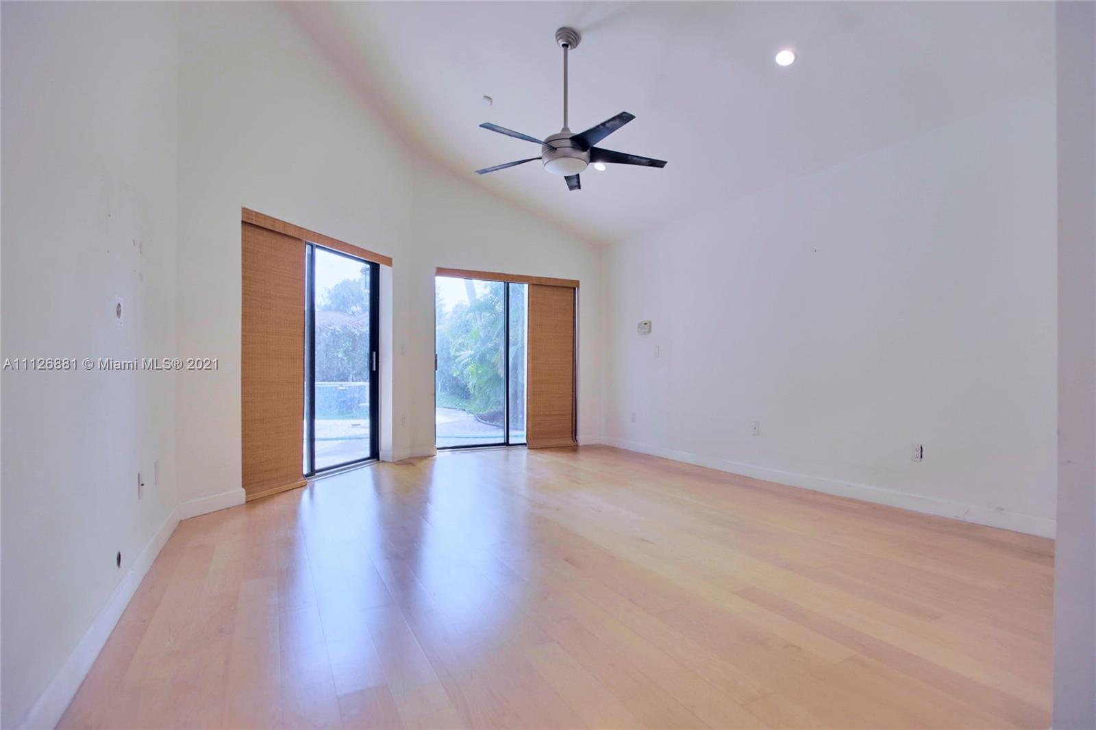 10726 Santa Rosa Drive Boca Raton, FL 33498 - Photo 15 of 26 an empty room with wooden floor fan and windows