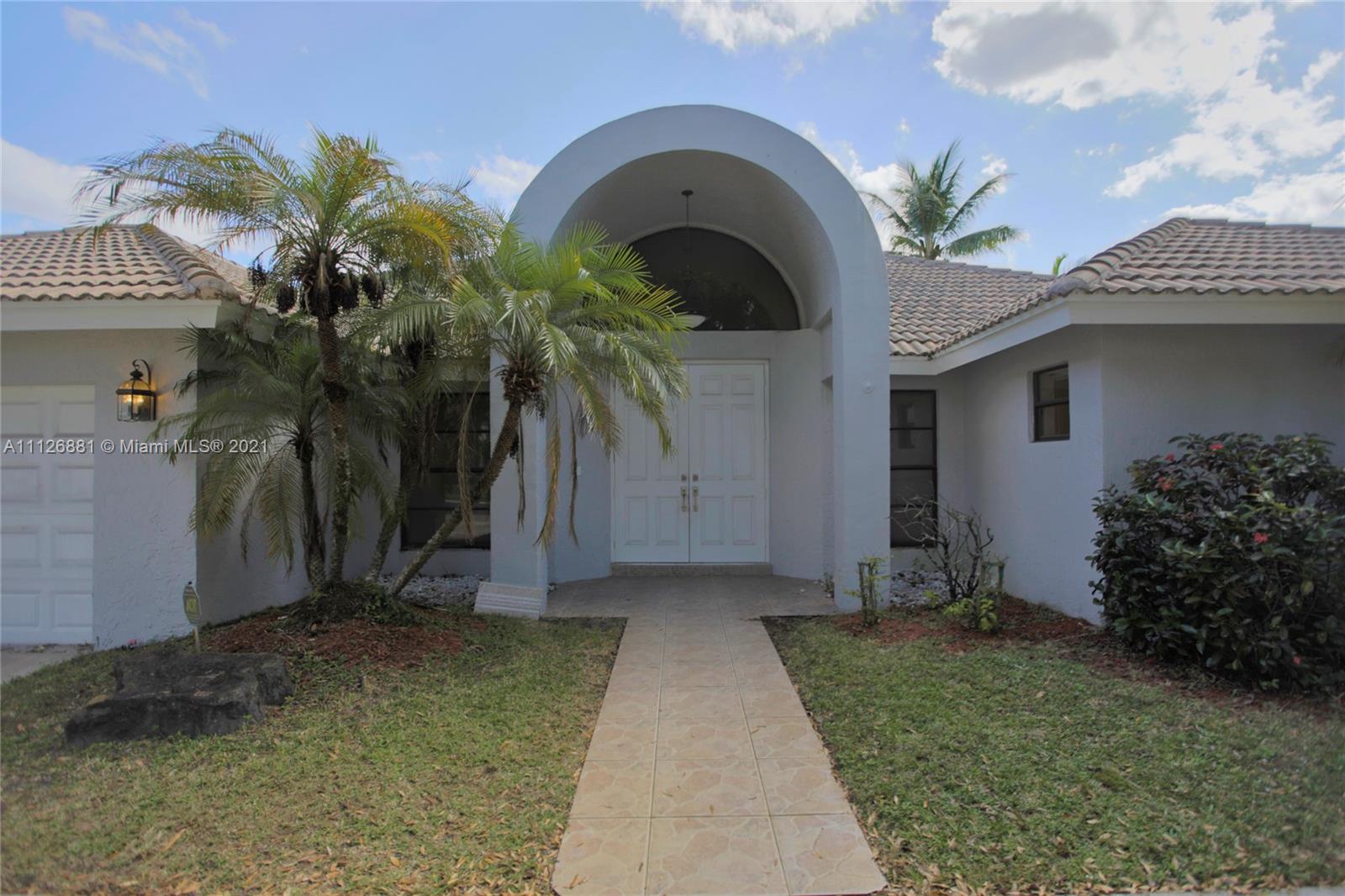 10726 Santa Rosa Drive Boca Raton, FL 33498 - Photo 3 of 26 a front view of a house with a garden