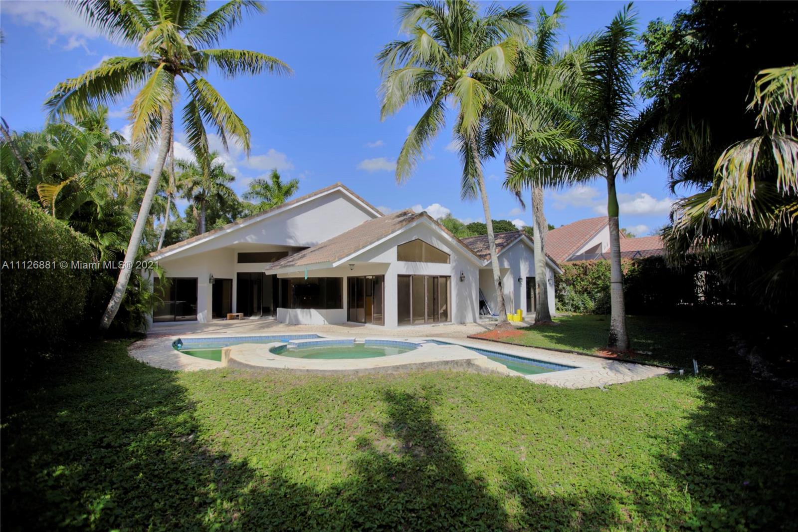 10726 Santa Rosa Drive Boca Raton, FL 33498 - Photo 6 of 26 a front view of a house with a yard and potted plants