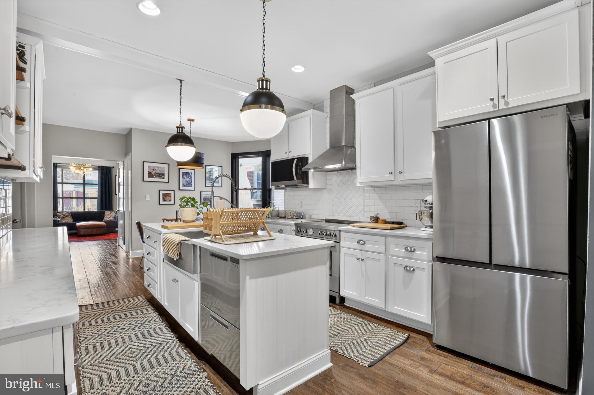 4315 Lauriston Street Philadelphia, PA 19128 - Photo 17 of 43 a kitchen with stainless steel appliances granite countertop a refrigerator a stove a sink dishwasher and a refrigerator with wooden floor