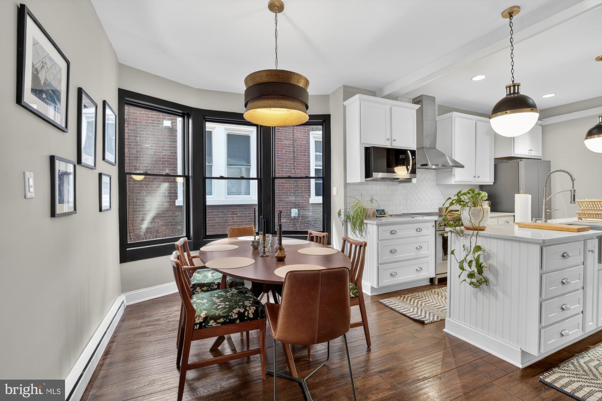 4315 Lauriston Street Philadelphia, PA 19128 - Photo 10 of 43 a kitchen with stainless steel appliances granite countertop a stove a refrigerator a kitchen island a table and chairs