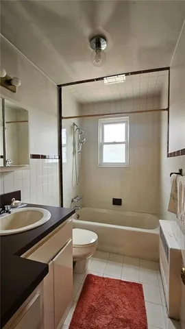 a bathroom with a sink a toilet a mirror and bathtub