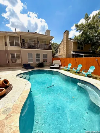 a view of a house with swimming pool and yard