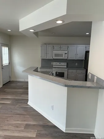 a kitchen with kitchen island a sink and wooden floor