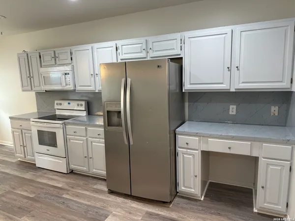a kitchen with white cabinets and stainless steel appliances