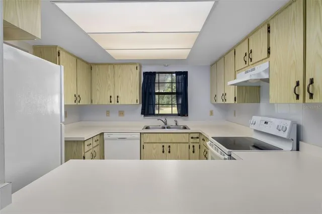 a kitchen with a sink cabinets and window