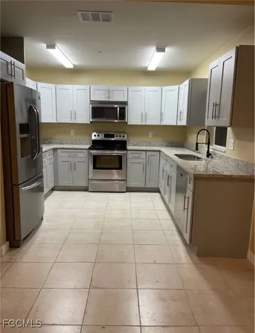a kitchen with stainless steel appliances granite countertop a refrigerator and a stove top oven