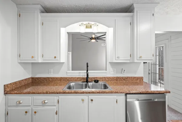 a kitchen with granite countertop a sink and cabinets