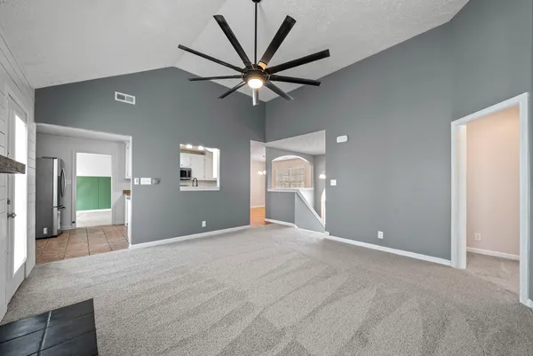 a view of a livingroom with a ceiling fan and wooden floor