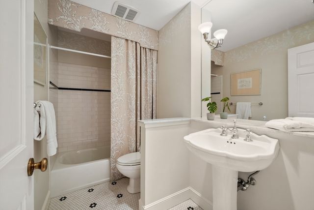 a bathroom with a sink a toilet a mirror and shower