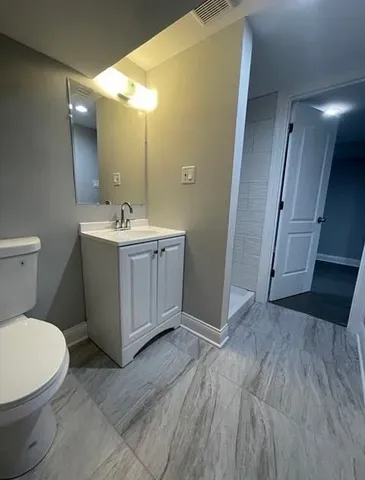 a bathroom with a sink and mirror with toilet