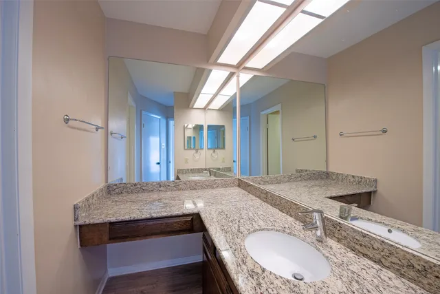 a en suite bathroom with a granite countertop sink and a mirror