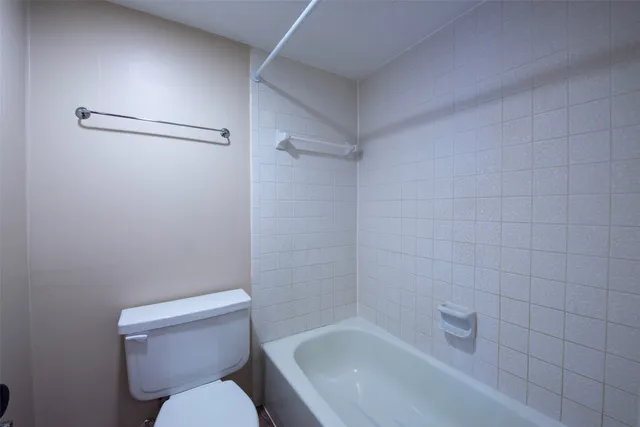 a white toilet sitting next to a bath tub