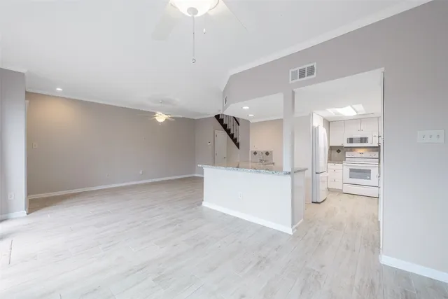 a view of kitchen and kitchen with stainless steel appliances wooden floor