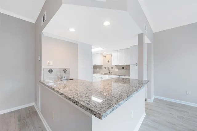 a view of kitchen island a sink and wooden floor