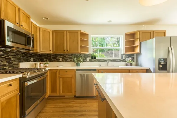 a kitchen with sink refrigerator and large window