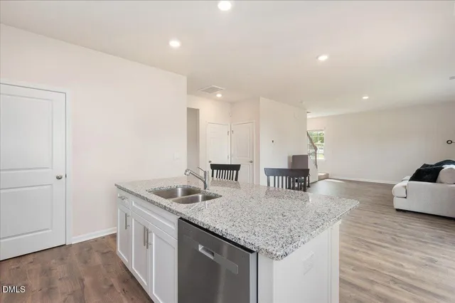 a kitchen with stainless steel appliances granite countertop a sink and a refrigerator