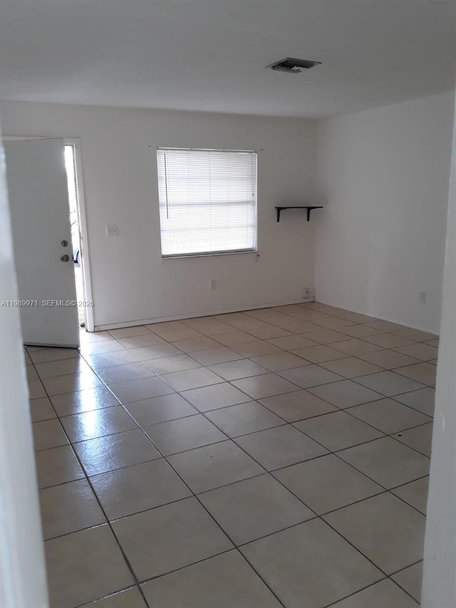 4380 Lakewood Road, Unit 4380 Lake Worth, FL 33461 - Photo 13 of 17 an empty room with a white cabinet and a window