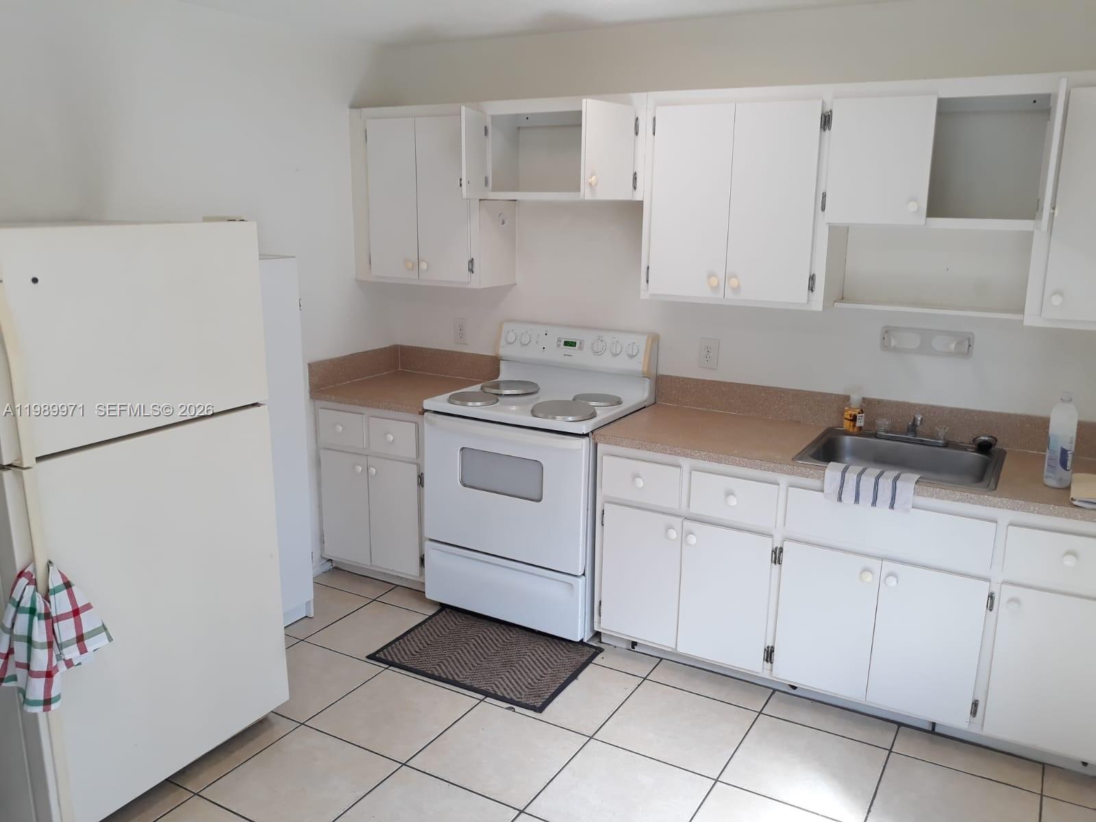 4380 Lakewood Road, Unit 4380 Lake Worth, FL 33461 - Photo 15 of 17 a kitchen with cabinets appliances and a sink