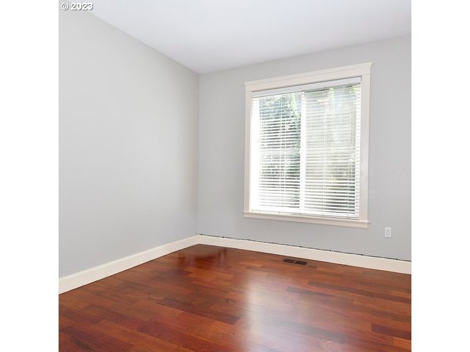 12614 Southeast Tibbetts Street Portland, OR 97236 - Photo 23 of 31 a view of an empty room with wooden floor and a window
