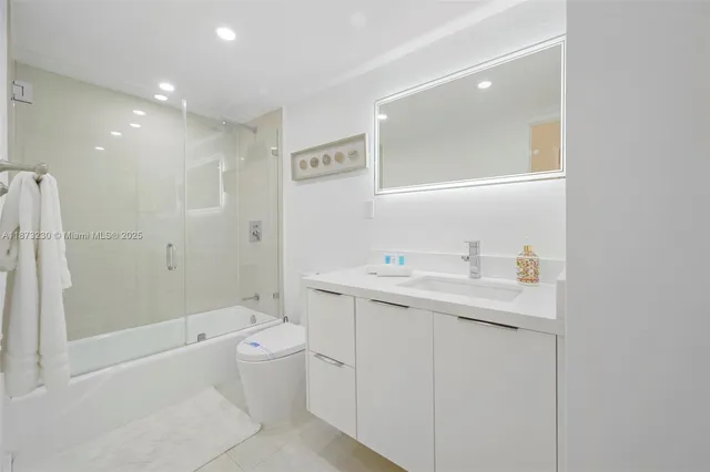 a bathroom with a bathtub shower sink mirror and toilet