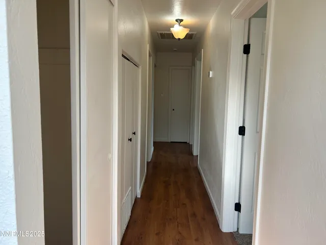 a view of a hallway with wooden floor