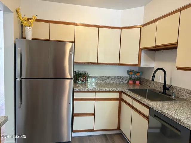 a kitchen with stainless steel appliances granite countertop a refrigerator a sink and cabinets