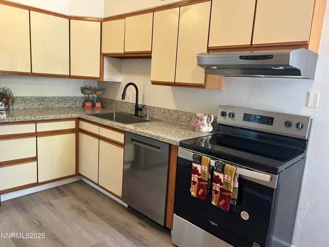 a kitchen with stainless steel appliances granite countertop a stove a sink and a microwave
