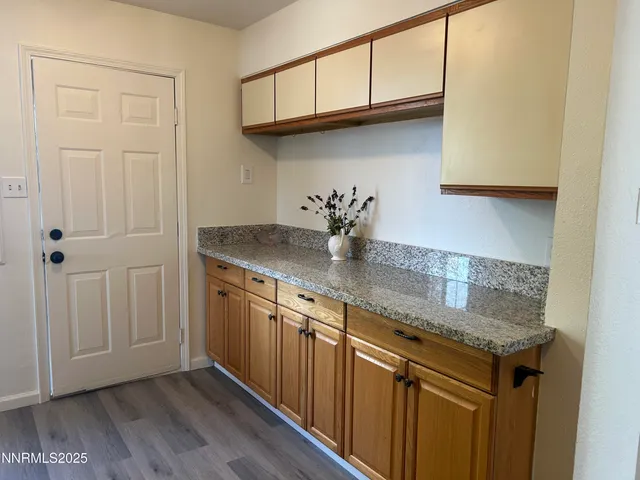 a kitchen with granite countertop a sink cabinets and wooden floor