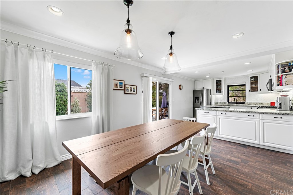 3040 Harding Way Costa Mesa, CA 92626 - Photo 6 of 17 a dining room with wooden floor a chandelier a wooden table and chairs