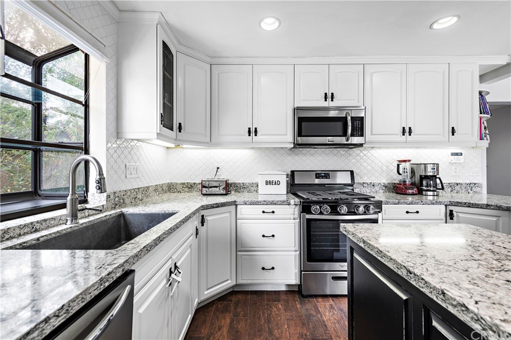 3040 Harding Way Costa Mesa, CA 92626 - Photo 7 of 17 a kitchen with granite countertop a sink a stove and cabinets